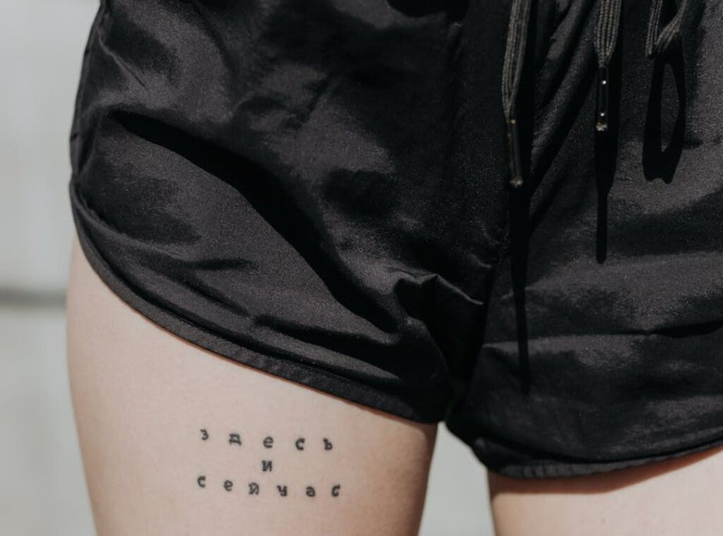 finos tatuajes pequeños en el muslo para mujeres